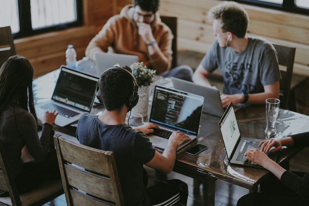 A group of remote data-work gig workers each focused on their own laptop